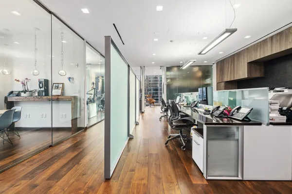 a view of a workspace with furniture and a window