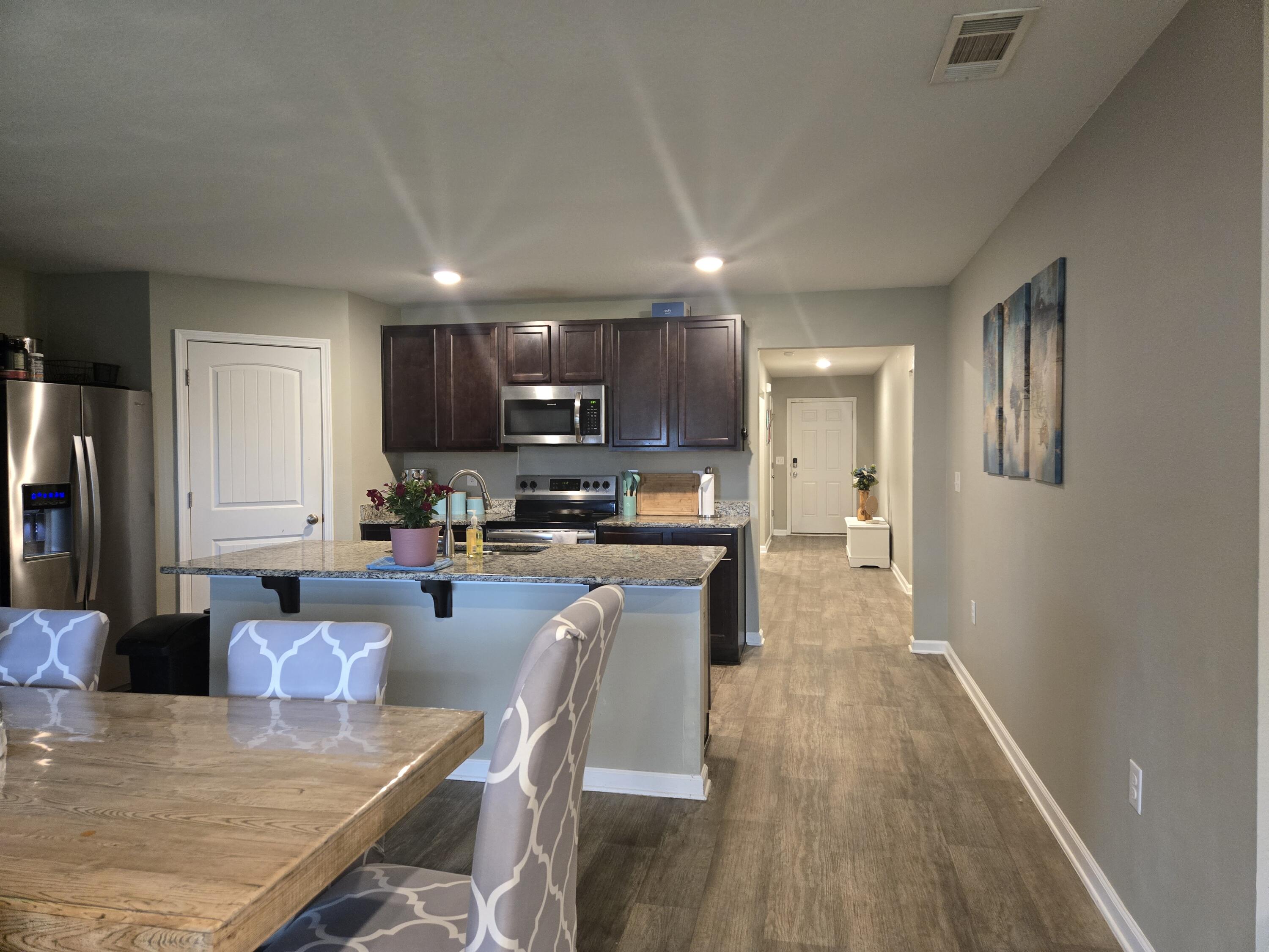 809 Moorhen Way Crestview, FL 32539 - Photo 7 of 24 a large kitchen with lots of counter space dining table and stainless steel appliances