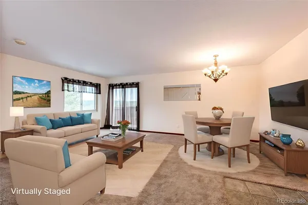a living room with furniture a flat screen tv and a window