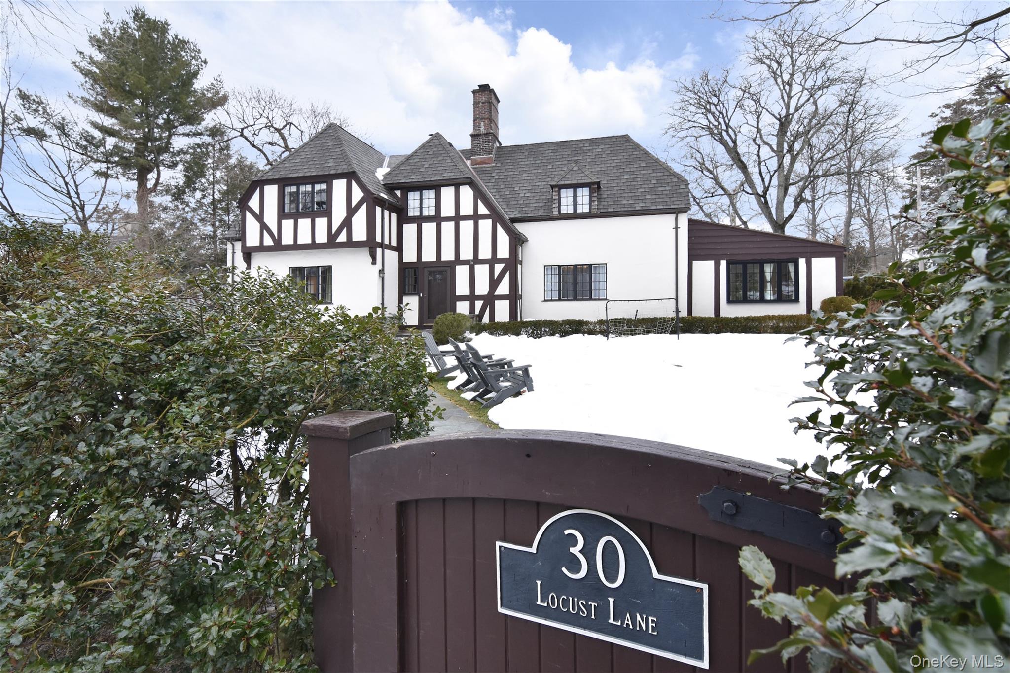 a front view of a house with a tree