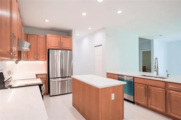 a kitchen with stainless steel appliances granite countertop a refrigerator and a sink
