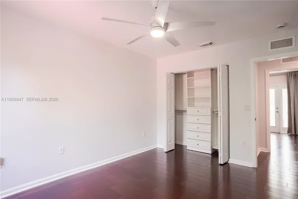 an empty room with wooden floor and closet