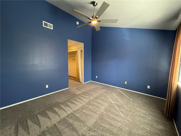 a view of an empty room with a ceiling fan and window
