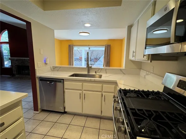 a kitchen with a sink a stove top oven and cabinets