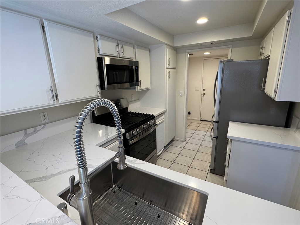 1254 Sand Creek Road San Dimas, CA 91773 - Photo 8 of 26 a kitchen with stainless steel appliances a stove a microwave a sink and a refrigerator