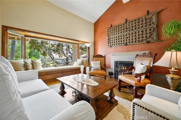 a living room with furniture fireplace and a large window