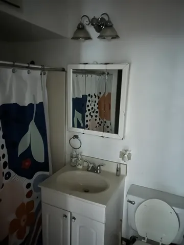 a bathroom with a toilet sink and mirror