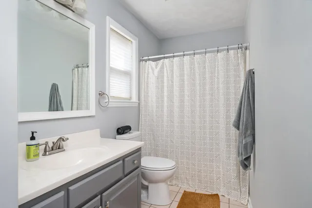 a bathroom with a granite countertop sink toilet and a mirror