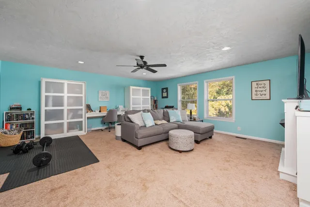 a living room with furniture gym equipment and a window