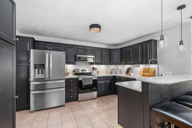 a kitchen with stainless steel appliances a stove a sink a refrigerator and cabinets