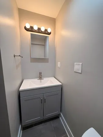 a bathroom with a sink a toilet and mirror