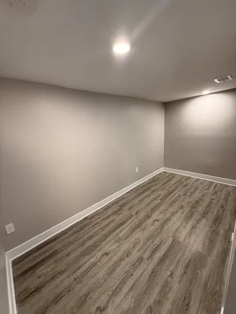 a view of room with wooden floor and windows