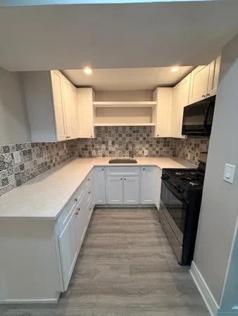 a large kitchen with a stove top oven and sink
