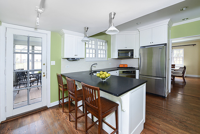 1004 Pontiac Road Wilmette, IL 60091 - Photo 9 of 28 a kitchen with stainless steel appliances granite countertop a stove a refrigerator a sink a dining table and chairs with wooden floor