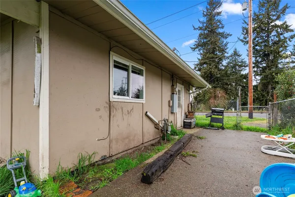a view of a house with a small yard plants and a large tree
