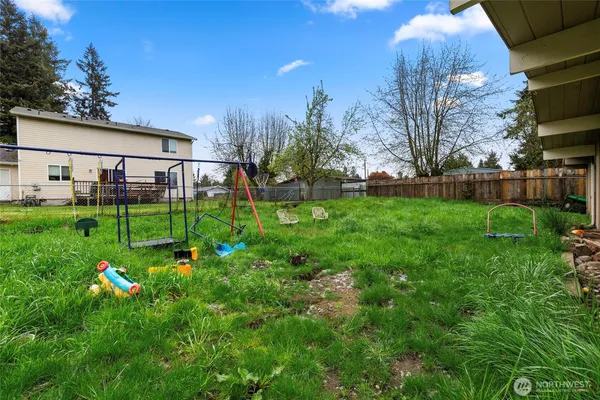 a view of a backyard with potted plants and large trees