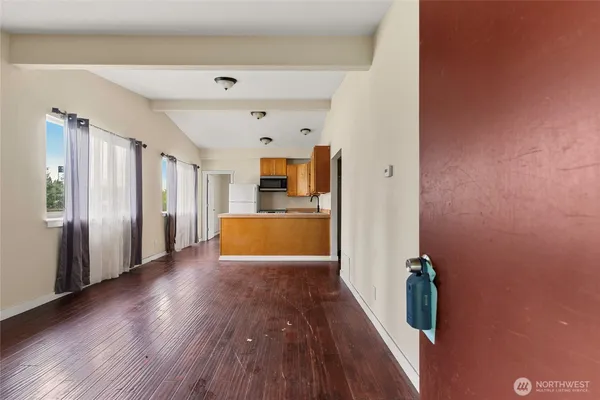 a view of a kitchen with wooden floor and electronic appliances