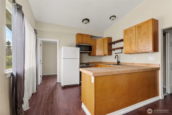 a kitchen with a refrigerator sink and wooden floor