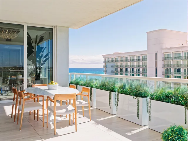 a view of a patio with a table and chairs and potted plants