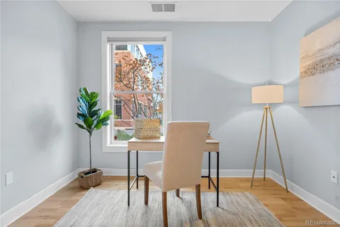 a view of a workspace with furniture and a window