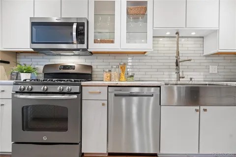 a kitchen with stainless steel appliances granite countertop a stove and a microwave