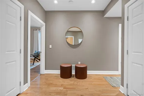 a view of a hallway with wooden floor and a potted plant