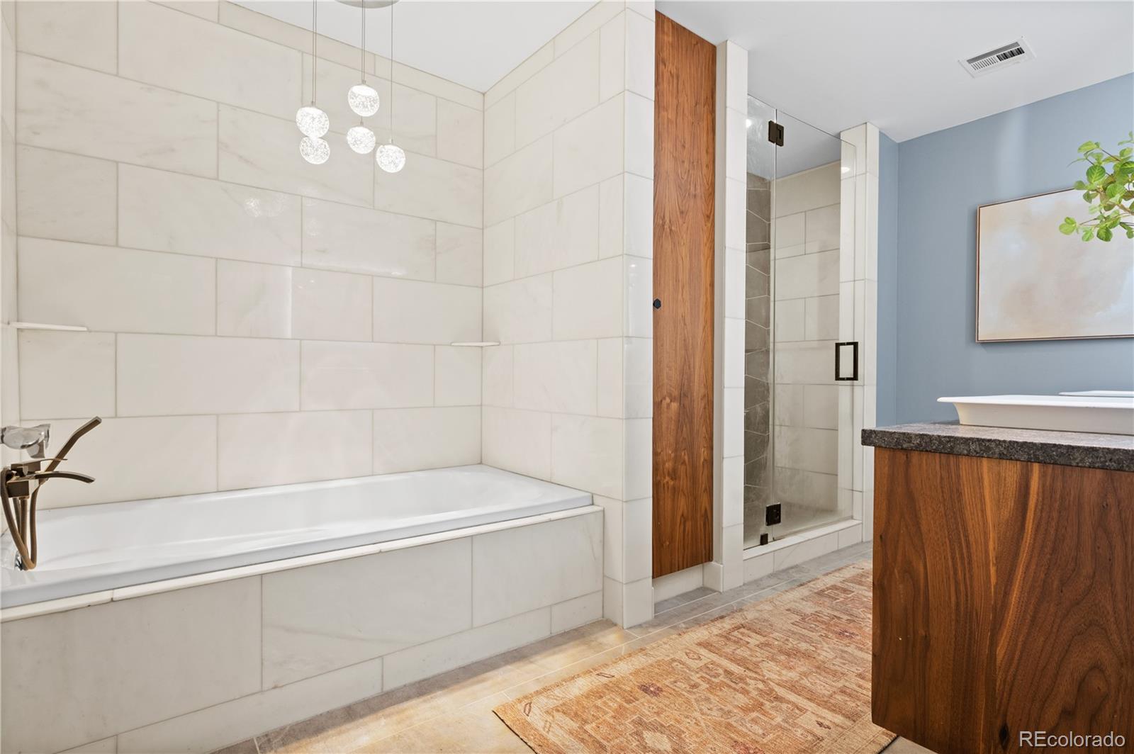 1630 North Clarkson Street, Unit 110 Denver, CO 80218 - Photo 10 of 36 a bathroom with a bathtub and a shower