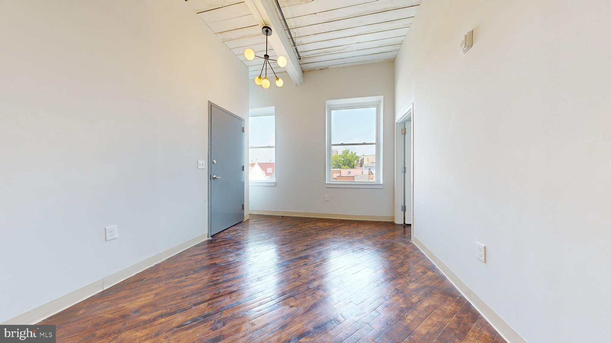 100 South 4th Street, Unit 301 Reading, PA 19602 - Photo 12 of 21 an empty room with wooden floor chandelier and windows