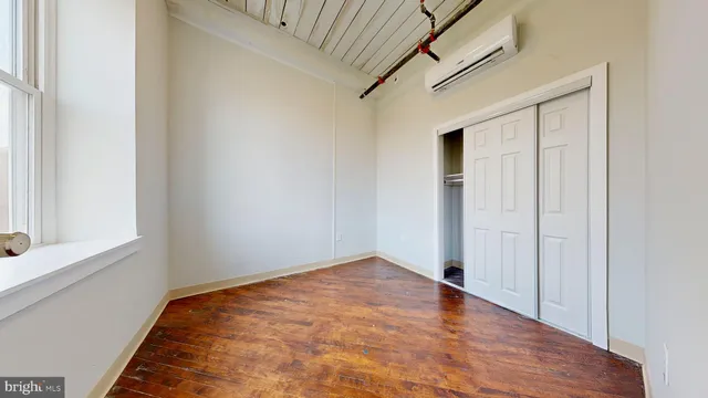 a view of empty room with wooden floor