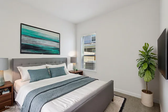 a bedroom with a bed potted plant and a window