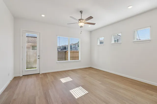a view of an empty room with a window and wooden floor