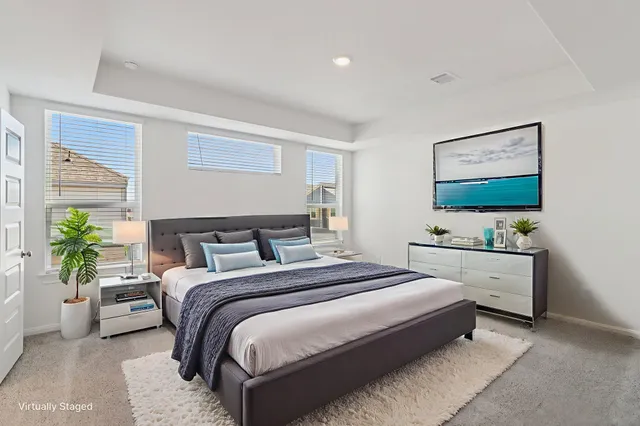 a spacious bedroom with a bed and a flat screen tv
