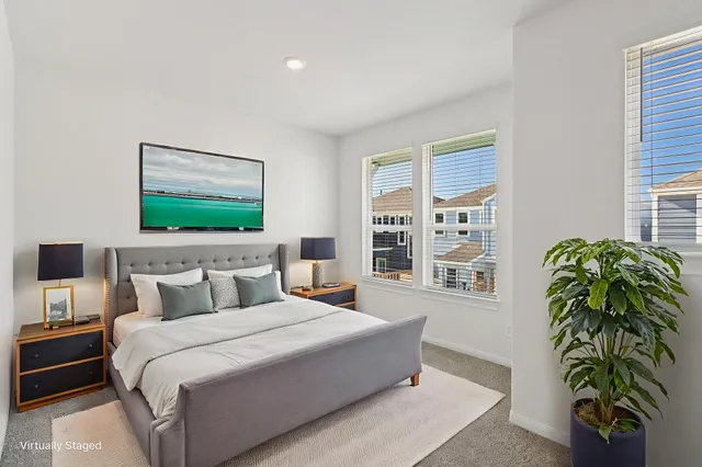 a bedroom with a large bed and a potted plant