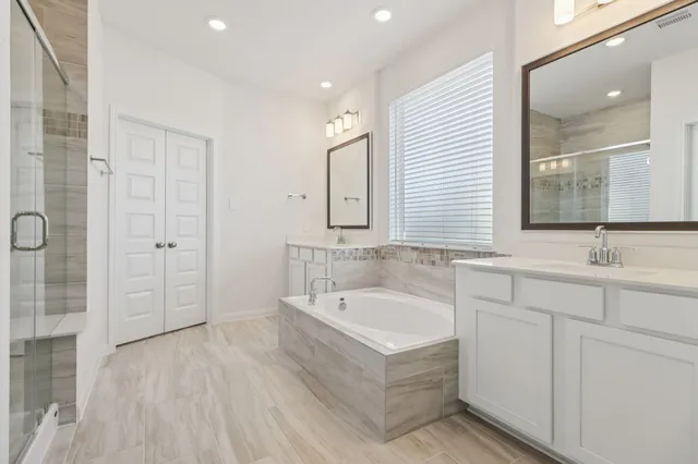 a bathroom with a tub sink and mirror