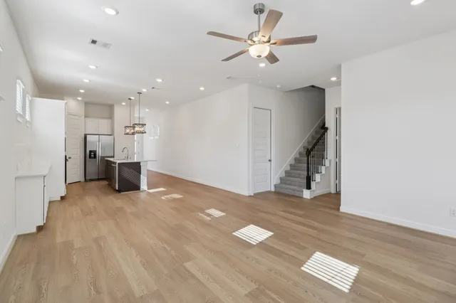 a view of a livingroom with wooden floor and staircase