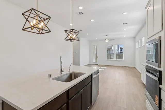 a kitchen with stainless steel appliances granite countertop a sink a oven and a refrigerator