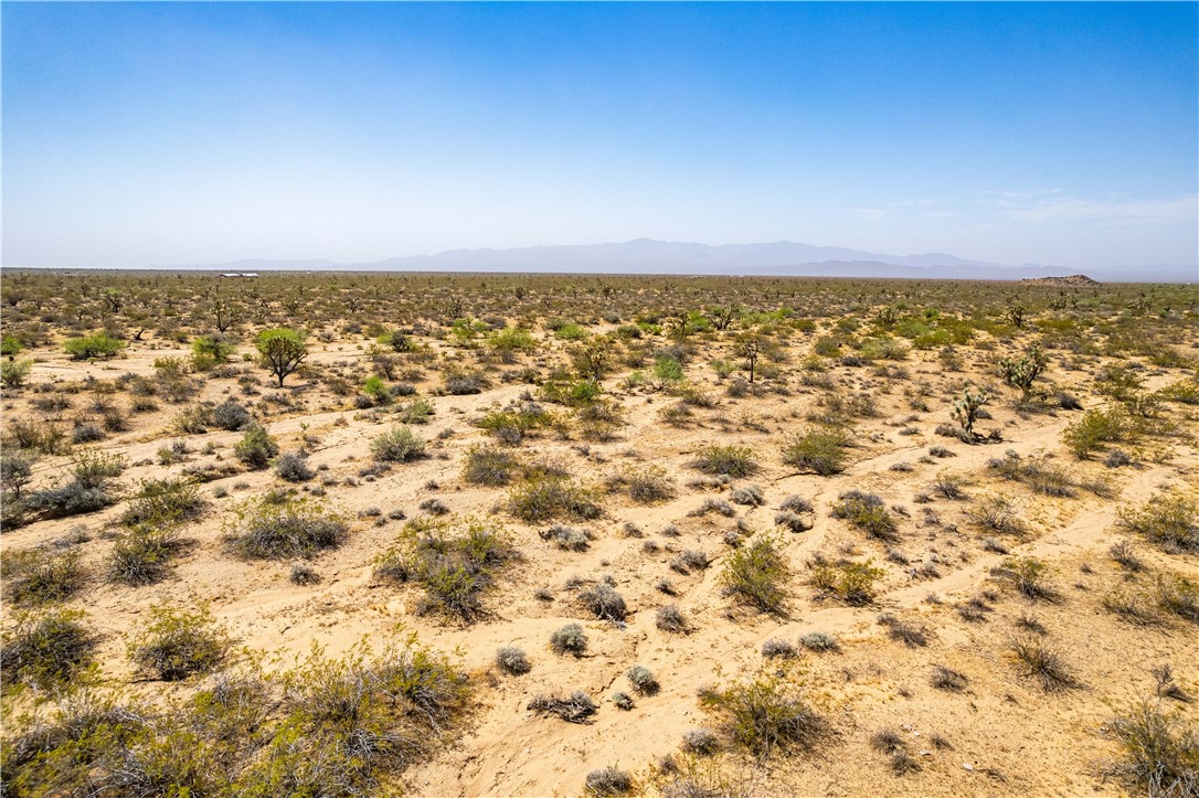 0 East Arroyo Road Yucca, AZ 86438 - Photo 24 of 25 Expansive desert landscape featuring various low-lying shrubs and distant mountains under a clear sky