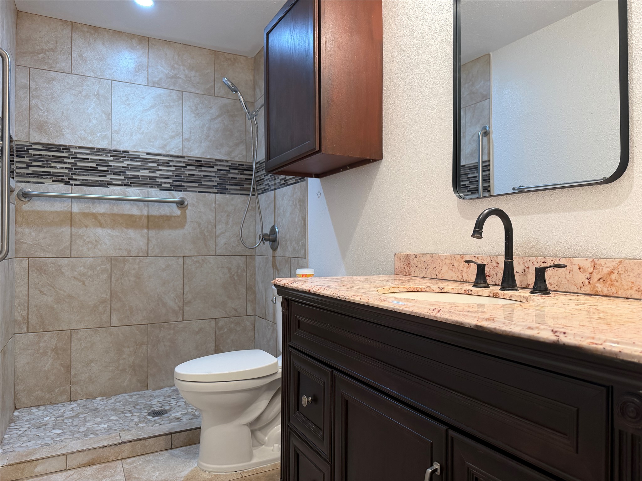 1060 Gardner Road Austin, TX 78721 - Photo 19 of 19 Marble countertops and rich wood cabinetry adorn this well-appointed bathroom.