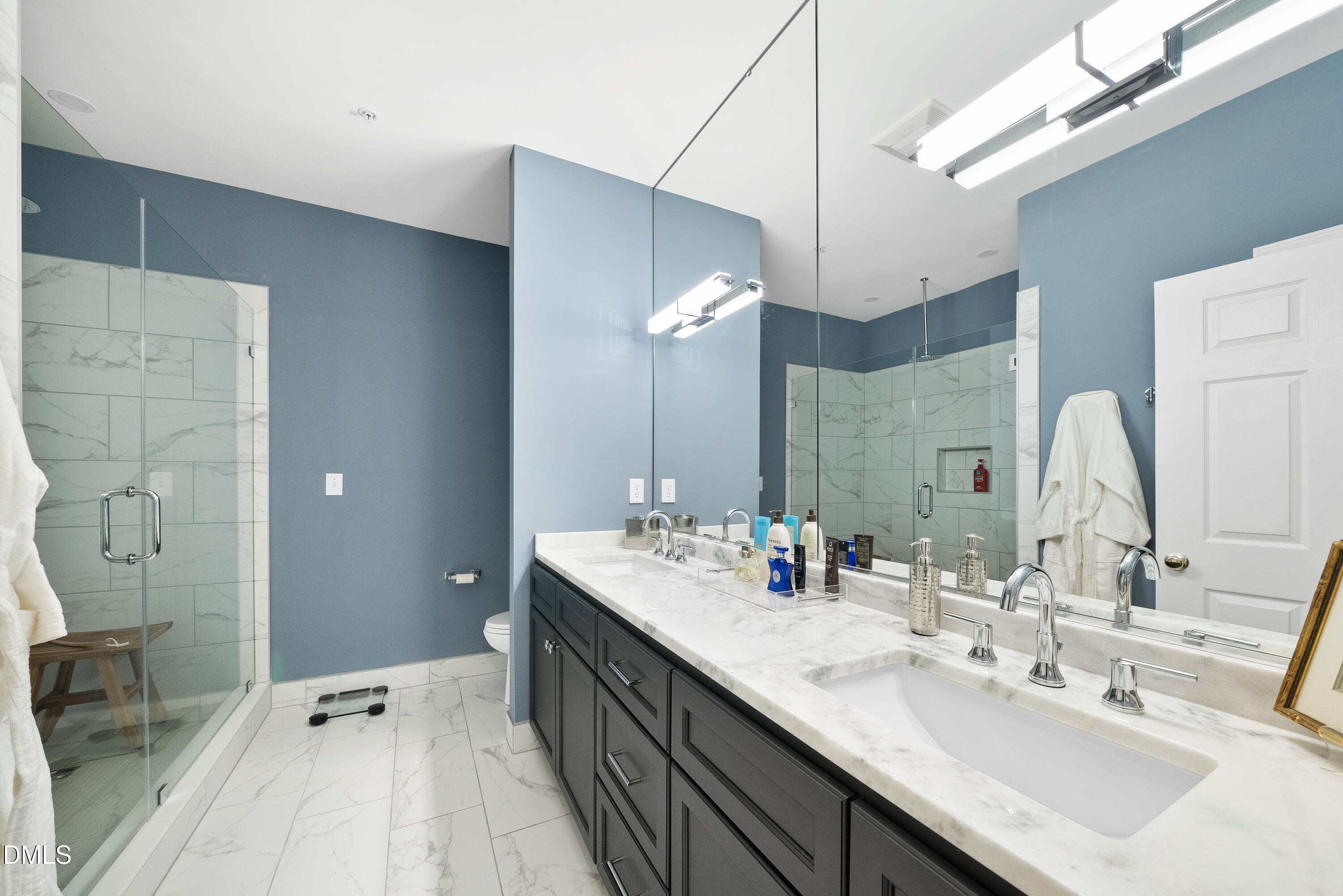 200 South Dawson Street, Unit 306 Raleigh, NC 27601 - Photo 17 of 24 a bathroom with a double vanity sink a mirror and a shower