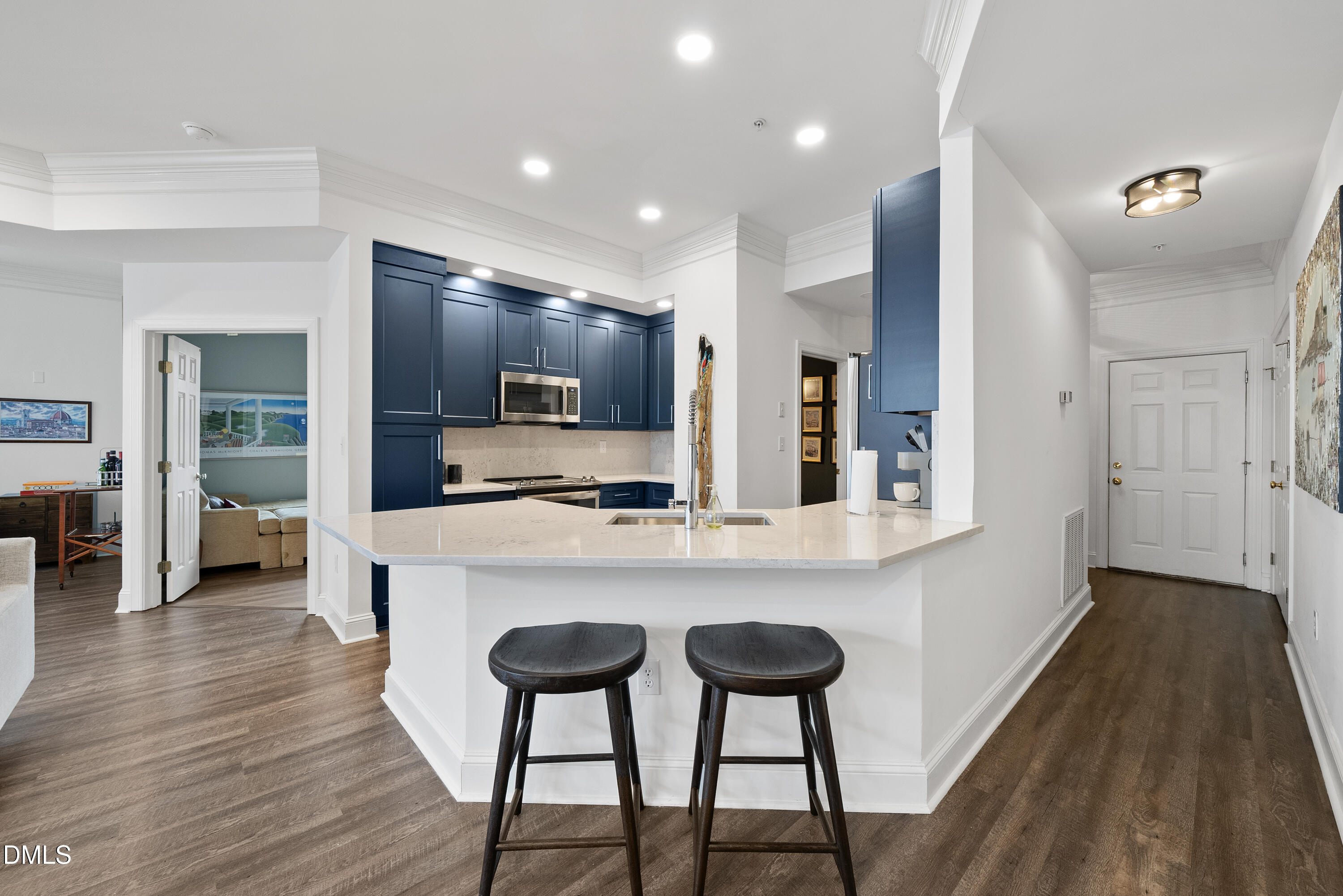 200 South Dawson Street, Unit 306 Raleigh, NC 27601 - Photo 5 of 24 a kitchen with kitchen island granite countertop wooden floors and refrigerator
