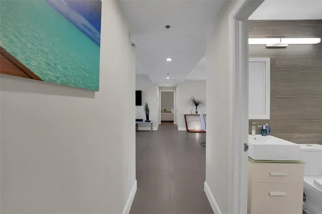 a living room with furniture floor to ceiling window and potted plants