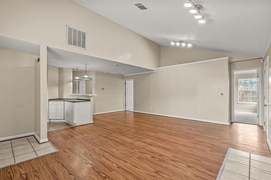a view of empty room with wooden floor