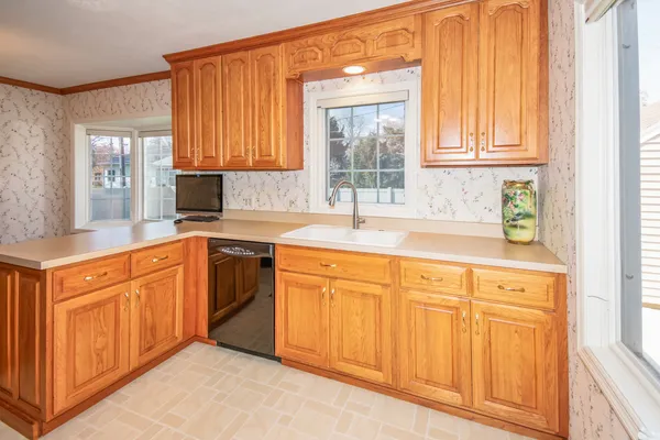 a kitchen with stainless steel appliances granite countertop a sink dishwasher and cabinets with wooden floor