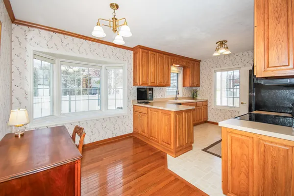 a large kitchen with stainless steel appliances wooden floors and wooden cabinets