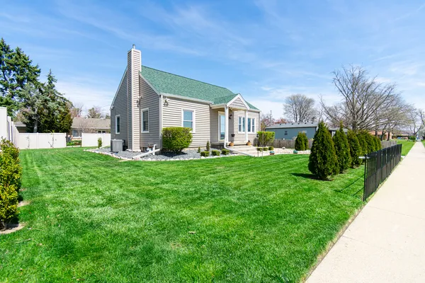 a front view of a house with a yard and green space