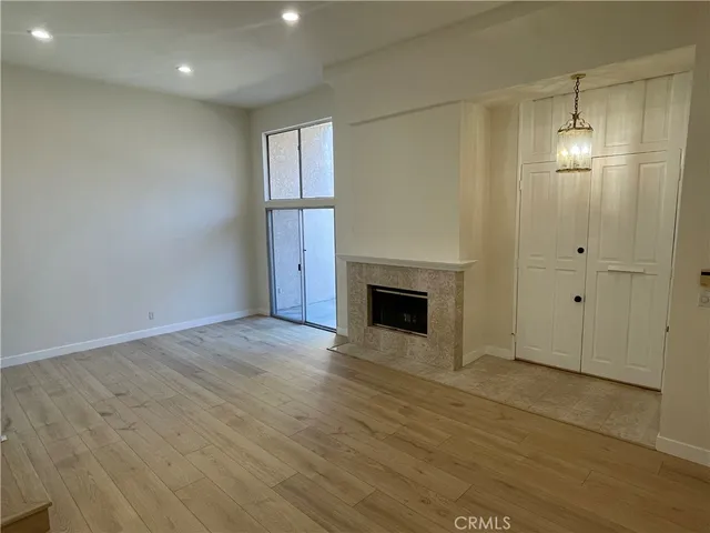 a view of empty room with wooden floor and fireplace