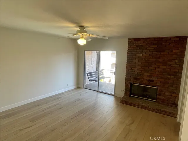 a view of an empty room with a fireplace and a window