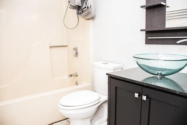 a bathroom with a granite countertop sink toilet and shower