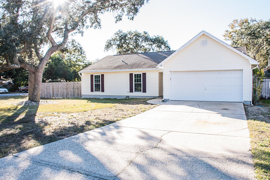 17 8th Avenue Shalimar, FL 32579 - Photo 2 of 25 a view of a white house with a large tree and wooden fence