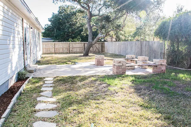 a view of a backyard with table and chairs and wooden fence